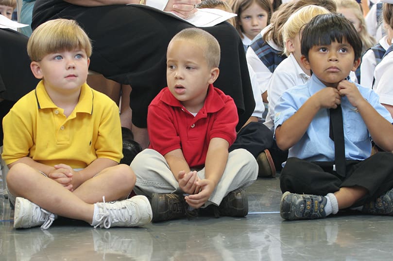 (L-r)  Bleu Swanson and Andrew Hackett sit in place as Markie Hutzler adjusts his tie. The pre-kindergarten students were awaiting the arrival of Archbishop Wilton D. Gregory to St. Mary's School, Rome, for a special Mass marking the school's 60th anniversary. Photo By Michael Alexander