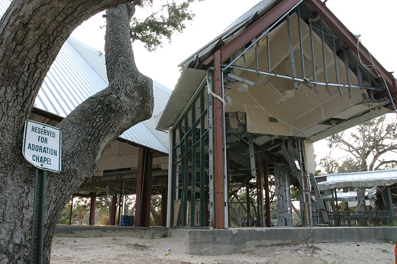 In late July a parking sign, propped up against a tree, marks the side of the St. Thomas the Apostle Church, Long Beach, Miss., where the adoration chapel and parish hall once existed. Photo By Michael Alexander