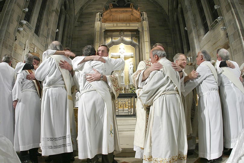 Newly ordained deacons (l-r, facing congregation) John Peterson, John Puetz, Thomas Ryan, Steve Swope and Richard Thibodeau are greeted with the kiss of peace by their brother permanent deacons from around the Archdiocese of Atlanta during the Feb. 8 rite of ordination at the Cathedral of Christ the King, Atlanta. Photo By Michael Alexander