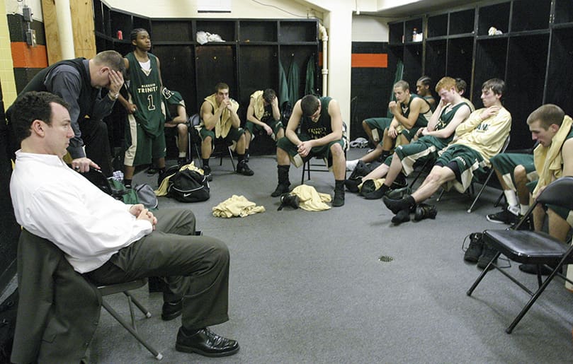 The end of their championship quest and playoff run weighs heavy on the team and coaches following the Fe. 26 game. The loss to a good team in a tough environment came on a night when Blessed Trinity had a season low 23 rebounds and 19 turnovers. Coach Marks, foreground left, was proud of the team's second half effort as they fought to the end. Blessed Trinity finished the season at 27-4, the most wins and best record in school history. Photo By Michael Alexander