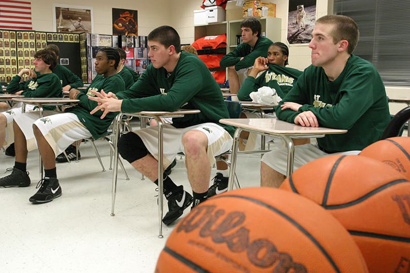 The team listens to a pre-game talk by Coach Marks before the Feb. 5 home game against Dunwoody. He said, “Be smart with the ball and take high percentage shots.” In a road game earlier in the season, Blessed Trinity defeated Dunwoody by five points. Photo By Michael Alexander