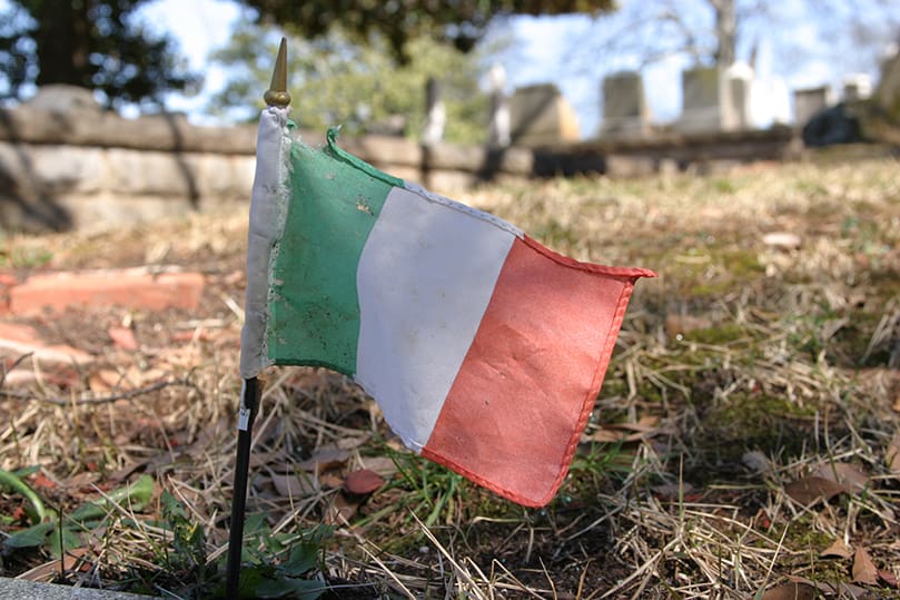 A tattered Irish flag in the Hibernian Benevolent Society section of Oakland Cemetery, Atlanta, is placed beside the grave of Thomas Michael Fessenden. The young man, born July 14, 1956 and died Dec. 13, 1975, was laid to rest before his 20th birthday. Photo By Michael Alexander