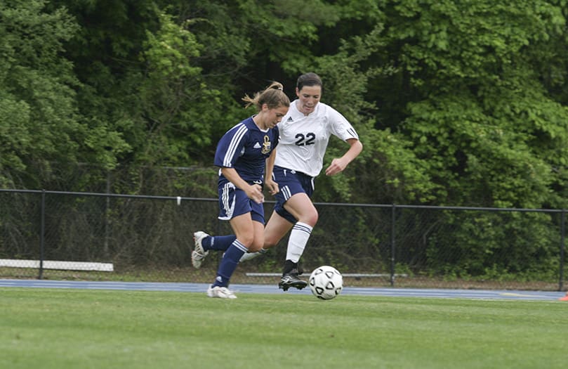 Marist School defender Shannon Fitzpatrick (#22) chases St. Pius X High School forward Alex Newfield as she advances the ball on the way to scoring the first goal of the state final match to give Pius a 1-0 lead in the first half. After extra periods Marist won the match during a penalty kick shootout 5-4. Photo By Michael Alexander