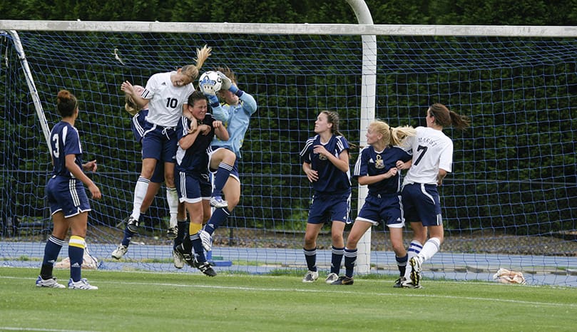 A header by Marist School forward Laura Eddy (#10) is blocked and caught by St. Pius X High School goalkeeper Emily Cox. Marist School captured its seventh soccer state title since 1988 with a 2-1 victory over archrival St. Pius X High School. Photo By Michael Alexander