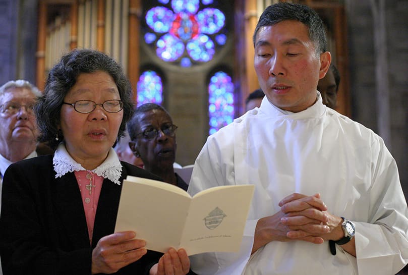 William Tan Hao, right, joins his older sister Elizabeth Ronkowski of Redondo Beach, Ca., in singing the traditional Glory To God. Photo By Michael Alexander