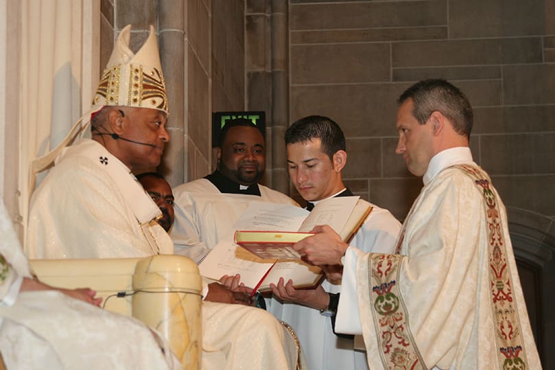 Rev. Mr.  Brian Thomas Lorei receives the Book of Gospels from Archbishop Gregory. Photo By Michael Alexander