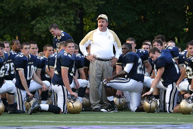 Coach Paul Standard stands among his players before their Sept. 5 game against Marist School. Standard has the second most wins of any football coach at St. Pius X High School behind George B. Maloof. Photo By Michael Alexander