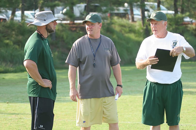 Ricky Turner, center, the head football coach at Blessed Trinity High School, Roswell, talks with his defensive backs coach Andy Harlin, left, and his first year offensive coordinator Bob Lord. Photo By Michael Alexander