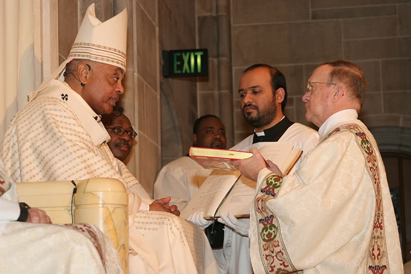 Archbishop Gregory presents the Book of Gospels to newly ordained Deacon Paul Gorski of Church of the Transfiguration, Marietta. Photo By Michael Alexander