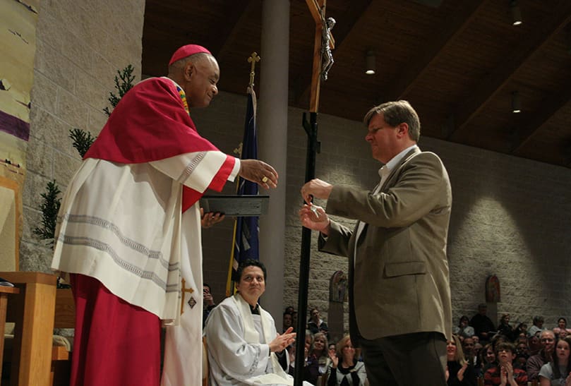 Mark Thurman, right, vice president of Collins and Arnold, the contractor for the project, presents the key and certificate of occupancy for the Family Life Center to Archbishop Wilton D. Gregory. Photo By Michael Alexander