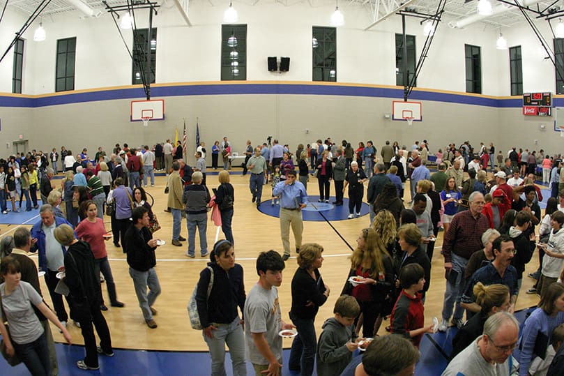 Parishioners enjoy the reception inside the new Family Life Center's gymnasium. Photo By Michael Alexander