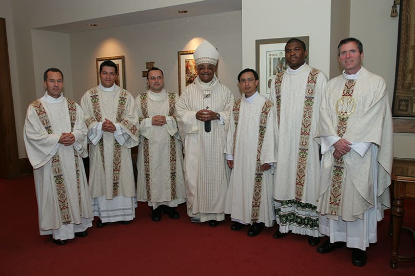 Archbishop Wilton D. Gregory, center, and Father Luke Ballman, director of vocations, far right, join the newly ordained transitional deacons (l-r) Thomas Zahuta, Mario Lopez-Castro, Carlos Vargas Silva, Thang Minh Pham and Chijioke Ogbuka for a group photo following the rite of ordination. Photo By Michael Alexander
