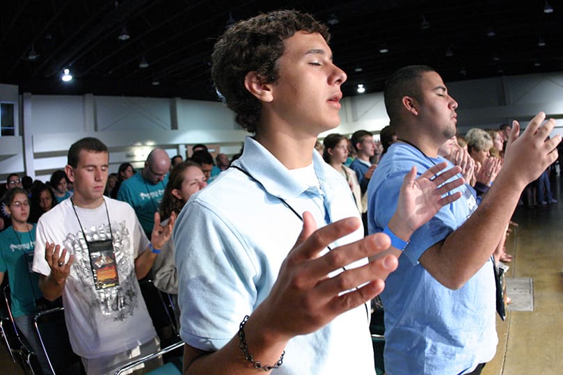 (Front row, l-r) Jonathan McGee, 16, and Michael Ropero-Cartier, 18, from St, Luke Church, Raleigh, N.C., pray the Our Father during Mass. Photo By Michael Alexander