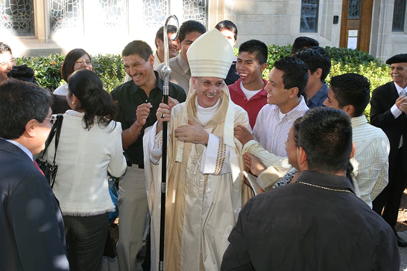Fifteen-year-old Jose Camacho of St. Helena Church, Clayton, on Bishop Zarama’s immediate left, laughs with the newly ordained bishop as he mingles with people on the cathedral plaza after the ordination.