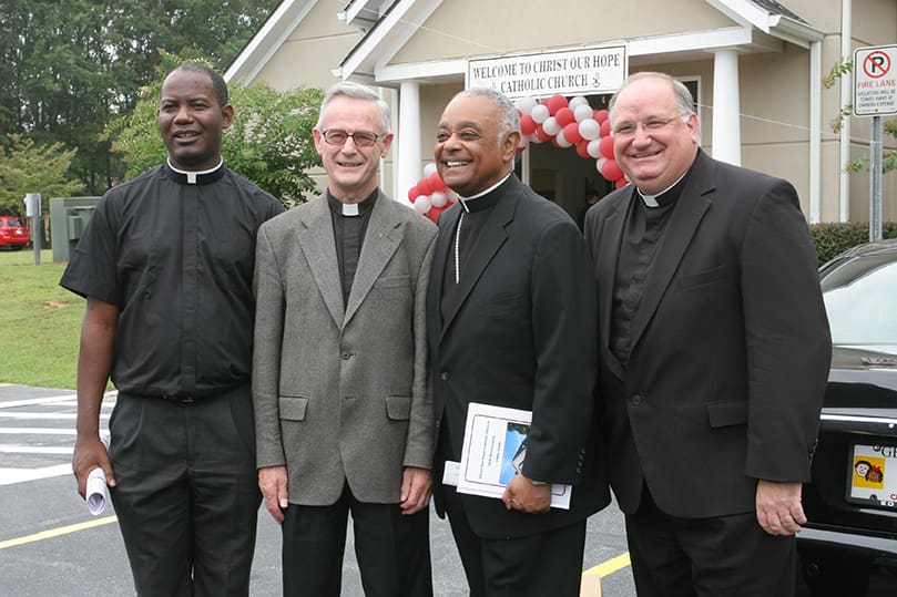 (L-r) Father Guyma Noel, current pastor of Christ Our Hope Church, joins the parish's first pastor Father John C. Kieran, currently the pastor of St. Pius X Church, Conyers, Archbishop Wilton Gregory, and former pastor Father Paul Flood, currently the pastor of St. Benedict Church, Johns Creek following the Aug. 30 anniversary Mass. Photo By Michael Alexander