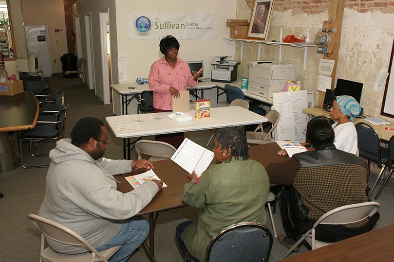 Sr-Marie-Sullivan-Sullivan-Ctr-Phyllis Renee Cain, Fulton County nutrition program assistant, standing, leads a class on nutrition at The Sullivan Center as a means to help educate families on the necessities of a balanced diet and to prevent future health problems. Photo By Michael Alexander