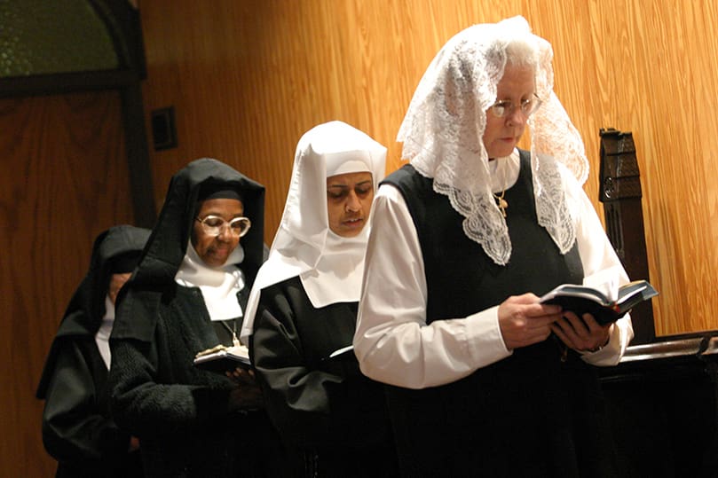 (Foreground to background) Prepostulate Christine Forrest, Sister Teresa, and Sister Mary of the Sacred Heart participate in the Divine Office of morning prayer. The sisters pray the Divine Office five times a day. Photo By Michael Alexander