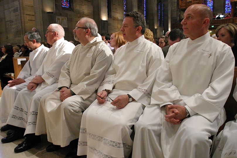 Permanent deacon candidates (l-r) Felix Rentas, Wayne Nacey, John McGuire, Ronald Manning and Robert Klein listen to Archbishop Wilton D. Gregory's homily from the front pew at the Cathedral of Christ the King. Photo By Michael Alexander