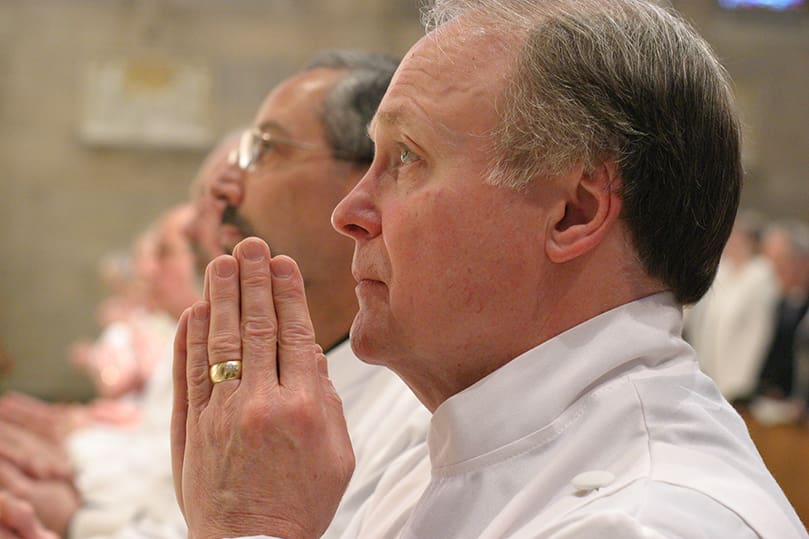 Gerald Zukauckas and his 14 fellow permanent deacon candidates kneel at the Communion rail as Archbishop Gregory conducts the prayer of consecration during their Feb. 4 rite of ordination at the Cathedral of Christ the King, Atlanta. Photo By Michael Alexander