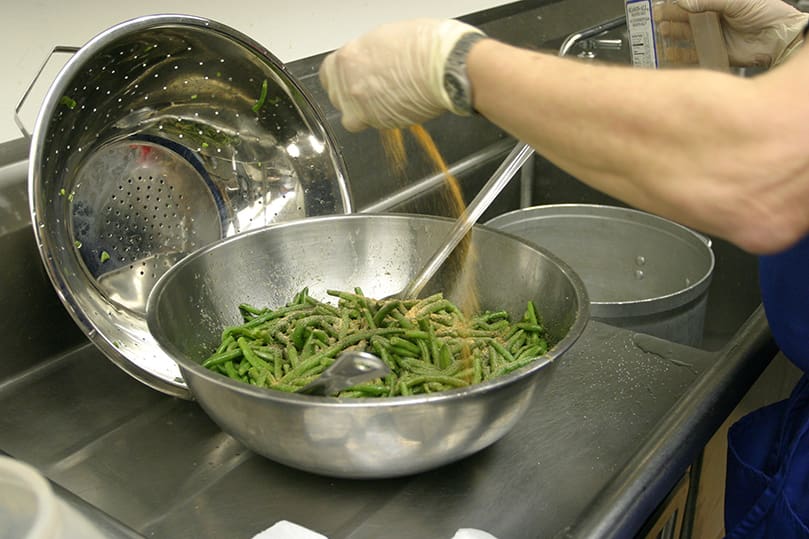 Bill Lucker prepares the green beans, one of the signature dishes on the fish fry menu. Photo By Michael Alexander
