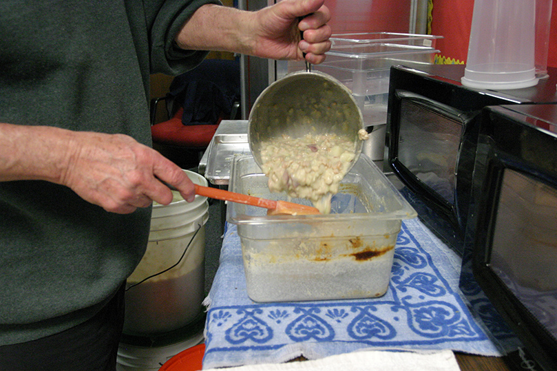 Ray Gustine pours out a dish of the clam chowder, a fish fry favorite. Photo By Michael Alexander