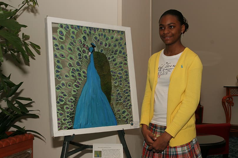 Thirteen-year-old Brittany Gates stands by her painting of a blue peacock, which is native to India. Gates said, 