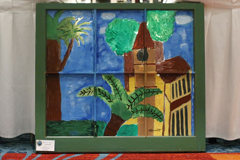 Leocadia Tchouaffe's painting of a German church in Cameroonâs southern city of Kribi was one of the 31 paintings done by seventh grade artists from St. John the Evangelist School who participated in the 10th annual Windows Art Exhibit at the Renaissance Concourse Atlanta Airport Hotel, March 5. All of the art is framed with donated and recycled house windows. Photo By Michael Alexander