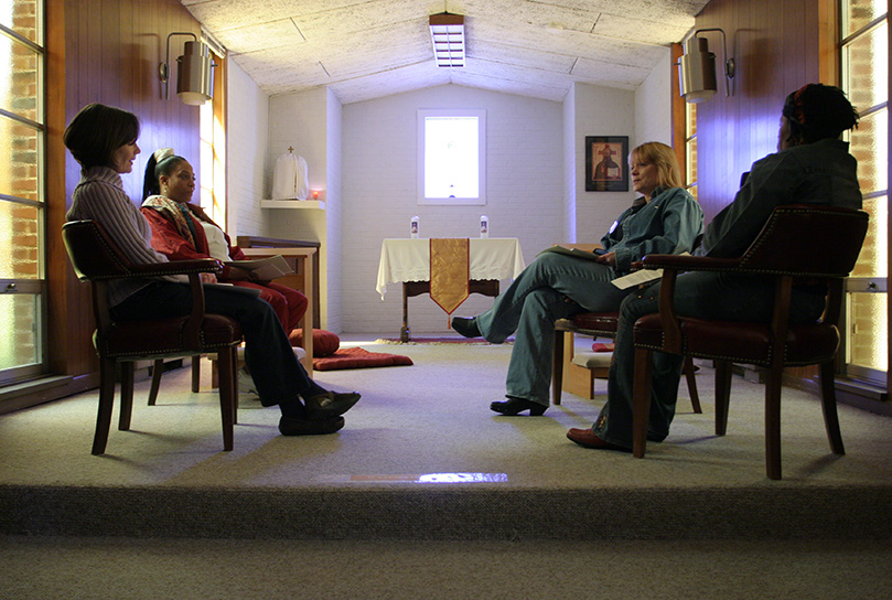 (Clockwise from left) Retreat facilitator Cathy Crosby of Our Lady of Lourdes Church, Atlanta, leads a moment of personal reflection inside the small chapel with Ignatian Spirituality Project retreatants Rochelle Poage, Tracy Mize and Carrie Eafford. Photo By Michael Alexander