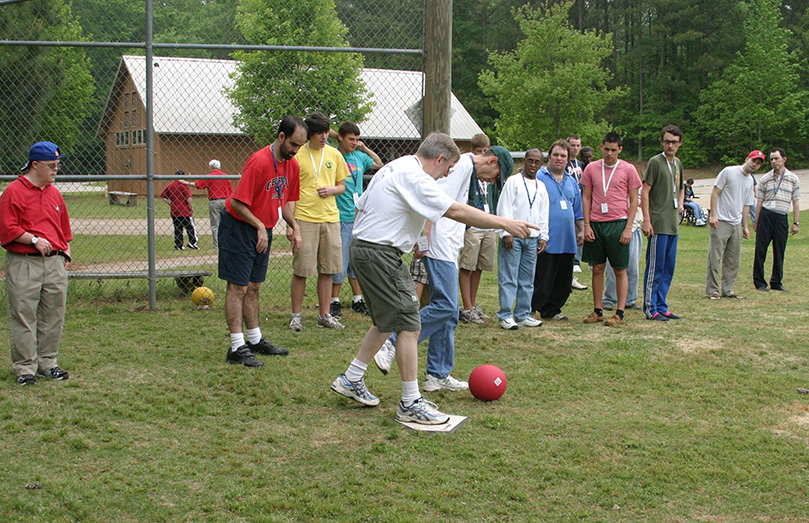 St. John Neumann volunteer Jack Marder helps camper Steve Abbott during a game of kickball. Marder was one of 80 adult volunteers in attendance at this year's camp. There were also 60 high school volunteers on hand. Photo By Michael Alexander