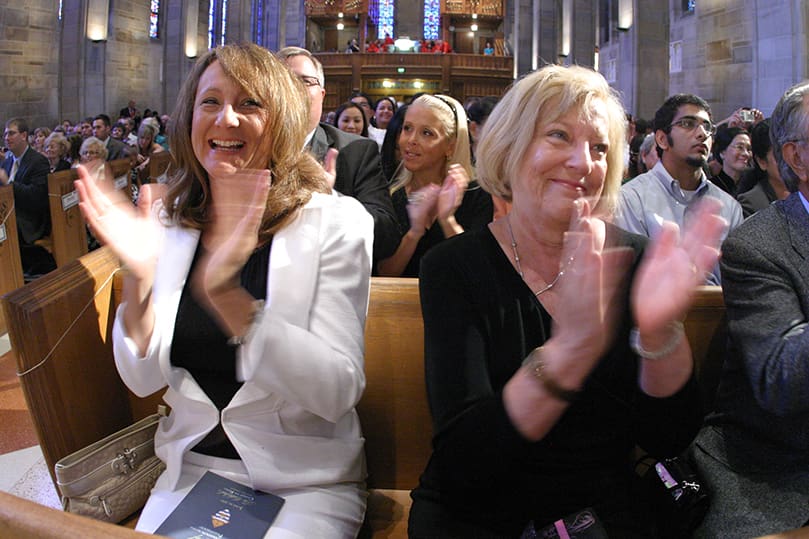 Deborah Briese, Llane Briese's mother, and Ozella Martinez, his grandmother from San Antonio, Texas, applaud during the presentation of the six ordination candidates. Photo By Michael Alexander