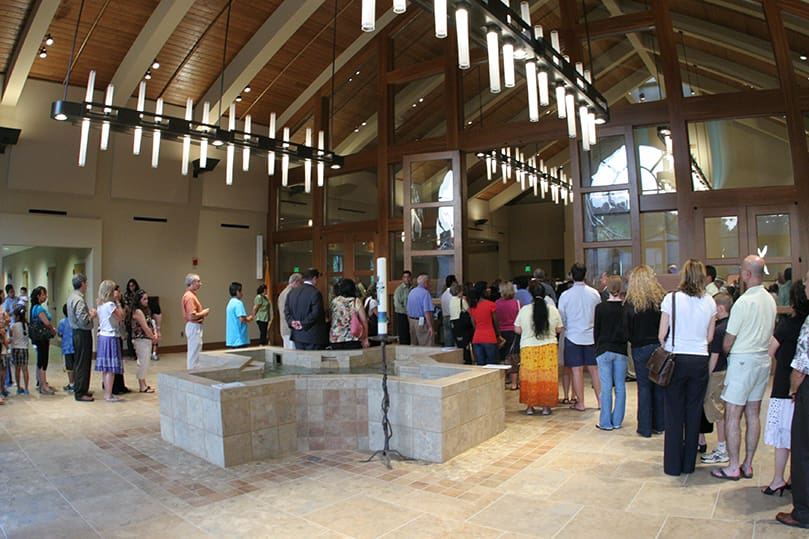 The overflow crowd, which occupied the lower level of the new structure and the old worship space, passes through the narthex on its way into the church to receive holy Communion. Photo By Michael Alexander