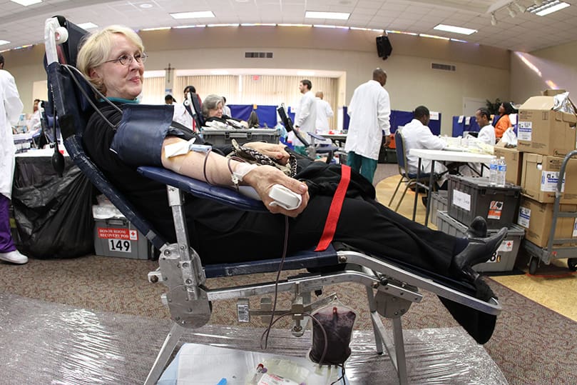 Kay Warthman stops by the Bob Buechner Blood Drive at her parish, Holy Cross Church, Dec. 11. Warthman, a nurse by profession, has been donating blood for 35 years. Photo By Michael Alexander