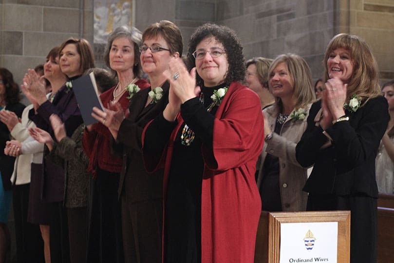 The wives of the 16 men to be ordained to the permanent diaconate give their husbands a standing ovation as they are presented to the congregation during the Feb. 5 rite of ordination. Photo By Michael Alexander