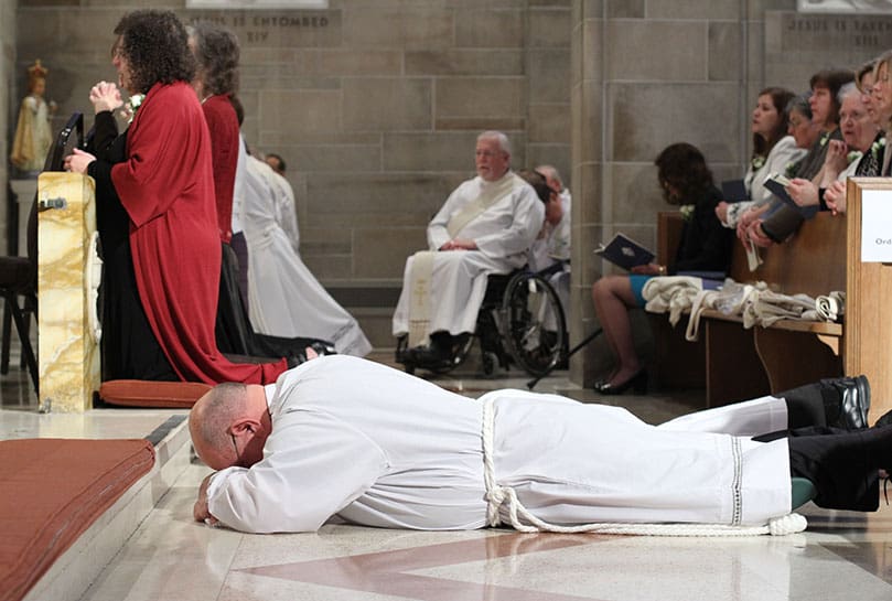 Fernando Barrueta of St. Pius X Church, Conyers, and the other diaconate candidates lie prostrate along the center aisle of the Cathedral of Christ the King during the Litany of the Saints. Photo By Michael Alexander