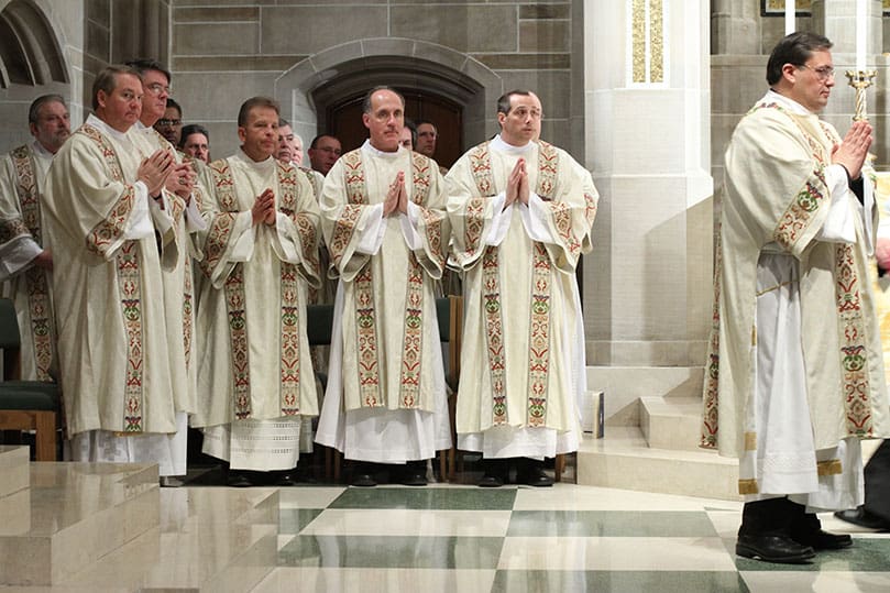 (Front row, l-r) Deacon Steve Swope, associate director of formation, Deacon Dennis Dorner, director of the permanent diaconate, and newly ordained deacons Gary Schantz, Bill Bohn and Bob Grimaldi stand during the Liturgy of the Eucharist. At the far right stands Deacon Joe Pupo, deacon of the cup. Photo By Michael Alexander