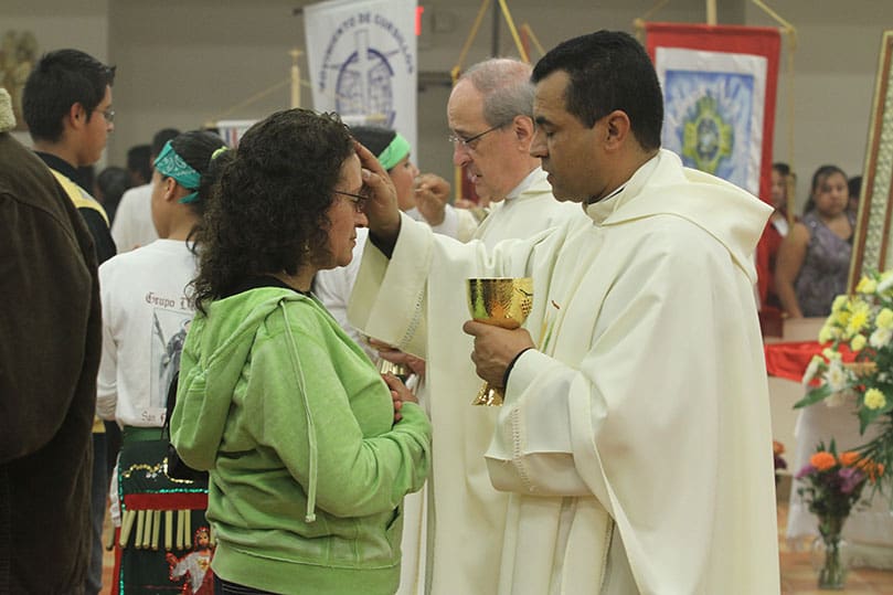 Father Jose Duvan Gonzalez, pastor of St Bernadette Church, Cedartown, extends a blessing to a woman during holy Communion. As administrator of San Felipe for eight years, Father Gonzalez was there when the mission was located in Grant Park and when it moved to Forest Park in 2002. Standing next to Father Duvan is Missionaries of St. Charles - Scalabrinians provincial Father Matthew Didone of New York. Photo By Michael Alexander                                                                         Father Jose Duvan Gonzalez, pastor of St Bernadette Church, Cedartown, extends a blessing to a woman during holy Communion. As administrator of San Felipe for eight years, Father Gonzalez was there when the mission was located in Grant Park and when it moved to Forest Park in 2002. Standing next to Father Duvan is Missionaries of St. Charles - Scalabrinians provincial Father Matthew Didone of New York. Photo By Michael Alexander Father Jose Duvan Gonzalez, pastor of St Bernadette Church, Cedartown, extends a blessing to a woman during holy Communion. As administrator of San Felipe for eight years, Father Gonzalez was there when the mission was located in Grant Park and when it moved to Forest Park in 2002. Standing next to Father Duvan is Missionaries of St. Charles - Scalabrinians provincial Father Matthew Didone of New York. Photo By Michael AlexanderFather Jose Duvan Gonzalez, pastor of St Bernadette Church, Cedartown, extends a blessing to a woman during holy Communion. As administrator of San Felipe for eight years, Father Gonzalez was there when the mission was located in Grant Park and when it moved to Forest Park in 2002. Standing next to Father Duvan is Missionaries of St. Charles - Scalabrinians provincial Father Matthew Didone of New York. Photo By Michael Alexander