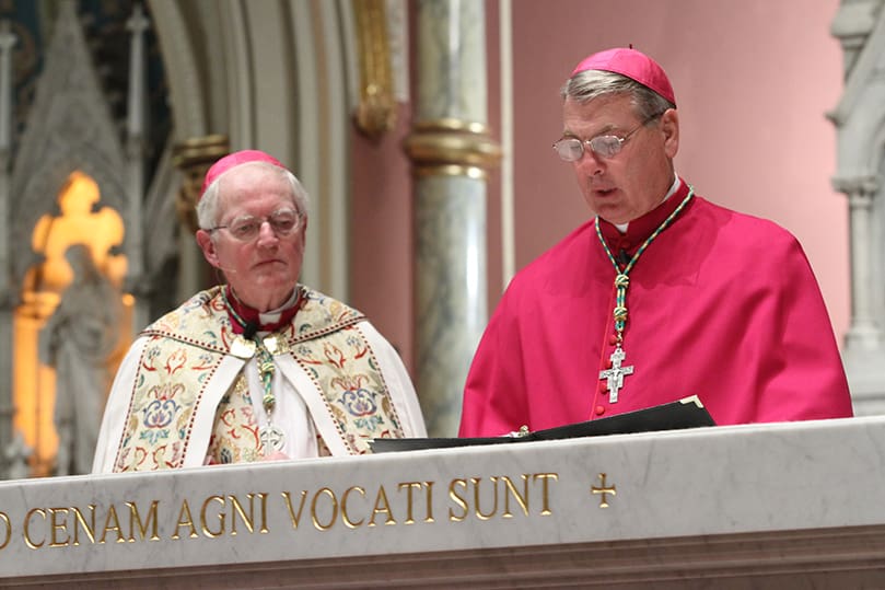 J. Kevin Boland, Bishop emeritus of Savannah, left, joins Bishop-elect Gregory John Hartmayer at the altar as Hartmayer makes his profession of faith and oath of fidelity before the congregation and clergy on hand for the solemn vespers. Photo By Michael Alexander