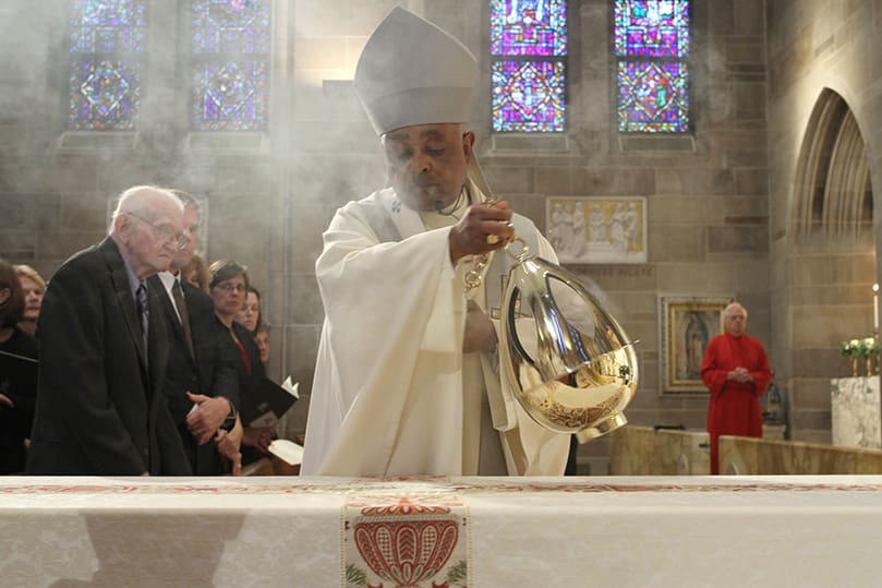 Archbishop Wilton D. Gregory, right, censes the body of Archbishop John F. Donoghue during the final commendation at the funeral Mass. Photo By Michael Alexander