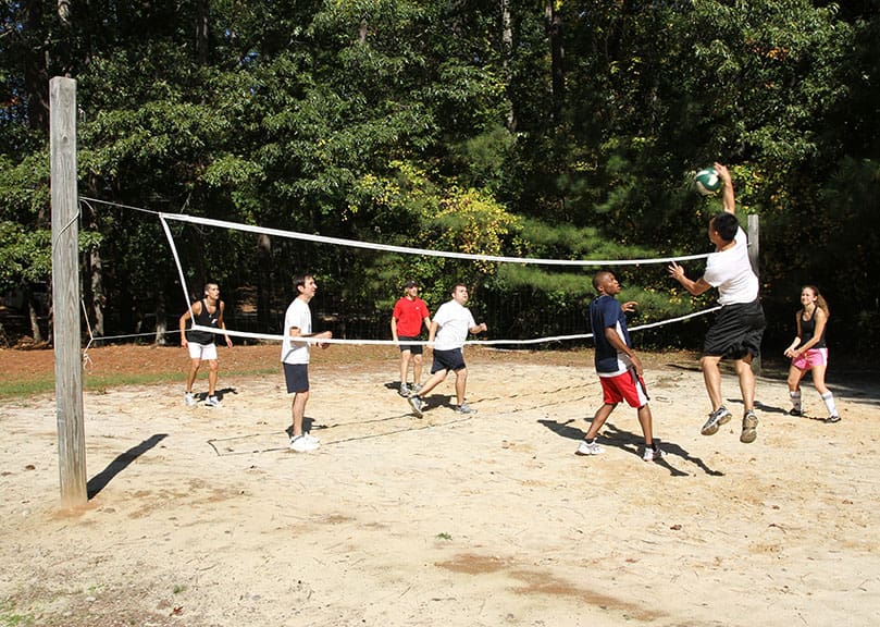 Danny Huynh of the Holy Vietnamese Church, Norcross, leaps to spike the ball over the opposing team during a game of volleyball. Young adults enjoyed some free time during an Oct. 15 retreat at the Simpsonwood Conference Center, Norcross.