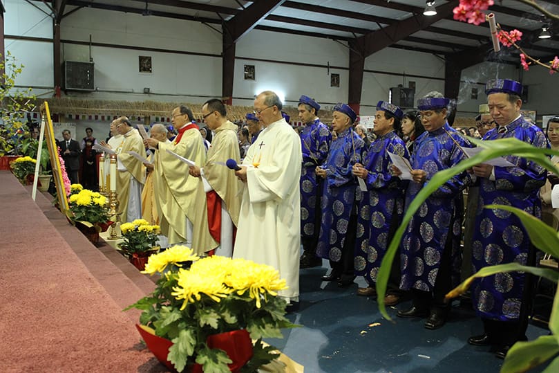 (Front row, r-l)  Deacon Joseph Phu Nguyen of Our Lady of Vietnam Church, Riverdale, Father Joseph Hieu Tran, a military chaplain on leave, Monsignor Francis Pham Van Phuong, pastor of Our Lady of Vietnam Church, Father Anthony Kiem Tran, retired, Father Peter Vu, Our Lady of Vietnam parochial vicar, and Deacon Peter Hung Huynh of Our Lady of Vietnam Church join the congregation in a litany of prayers for the Vietnamese New Year. Photo By Michael Alexander