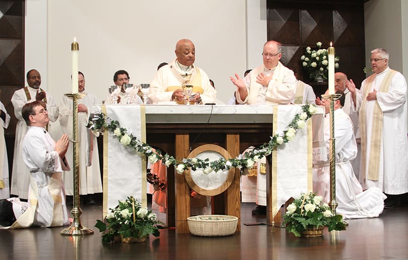 Archbishop Wilton D. Gregory, left center, is joined at the altar by St. Francis of Assisi Church pastor Father Daniel Stack and their brother clergy during the Liturgy of the Eucharist. Photo By Michael Alexander