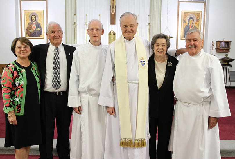(L-r) Joanna Warenzak Schoerner, Arnold Willegalle, Bill Maddox, Father Richard Morrow, the first pastor from 1960-1966, Virginia Willegalle and Jim Shadrix gather for a photo following the anniversary Mass. Maddox and Shadrix served at the March 26 Mass and the March 25, 1962 Mass. Photo By Michael Alexander