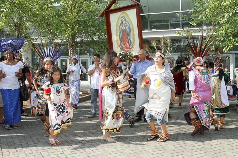 During an impromptu moment, some of the women from Nigeria join the Hispanic liturgical dancers from St. Thomas Aquinas Church, Alpharetta, as they dance outside the Georgia International Convention Center, College Park. Photo By Michael Alexander