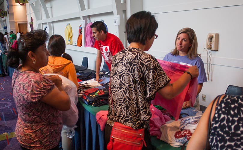 Jennifer Rollauer, far right, a member of the Cathedral of Christ the King, Atlanta, sees that T-shirts are available for sale to Catholic consumers throughout the day. Photo by Thomas Spink