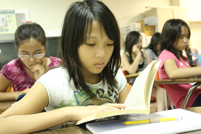 Sophia Tang, 10, reads the Michelle Bates book, Racing Vacation, during the morning class. The summer program participants were required to read a book and then do a summary and book report.  Photo By Michael Alexander