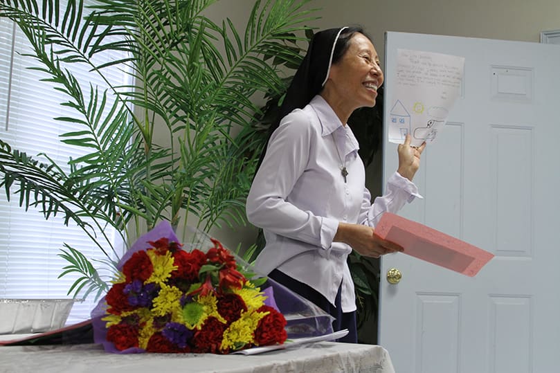 Sister of the Good Shepherd Christine Truong My Hanh, executive director of Good Shepherd Services, reads the thank you notes from summer program attendees on July 12, the last day of the program. She was also presented with a bouquet of flowers. Photo By Michael Alexander