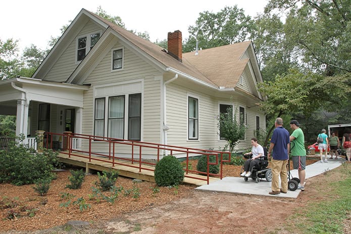 Lara Swenson, in the wheel chair, is the first core member to move into the L'Arche Atlanta home in Decatur, August 11. Looking on are executive director Curt Armstrong, left, and house assistant Tim Moore. Photo By Michael Alexander
