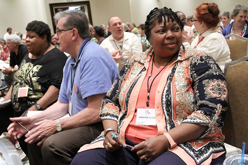 Christine Bluett, right, of St. Alphonsus Rock Church, St. Louis, Mo., and Bob Cooke, left center, of St. Rose of Lima Church, Gaithersburg, Md., participate in an exercise with their respective neighbors during the morning plenary session. Photo By Michael Alexander