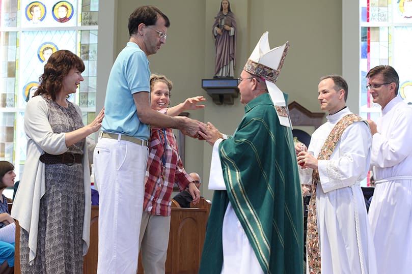 (L-r) Karen Ehmer of St. Jude the Apostle Church in Sandy Springs accompanies Scott Taquechel and Julie Doyal as they present the gifts of bread and wine to Bishop David P. Talley, auxiliary bishop of Atlanta. Looking on are Deacon Gerry Kazin and Derek Gant of St. Benedict Church. Photo By Michael Alexander