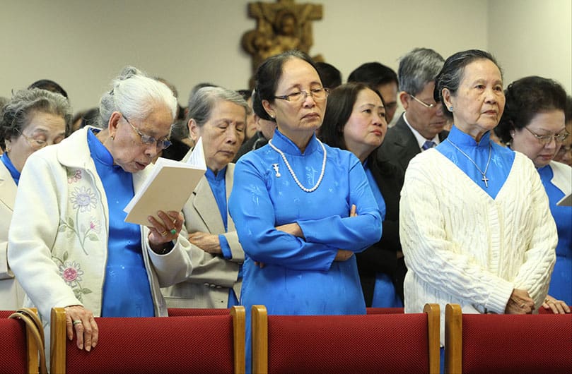 Members of the Guild of the Blessed Virgin Mary stand with others in the congregation during the reading of the Gospel from the Book of Matthewâs 24th chapter. Photo By Michael Alexander
